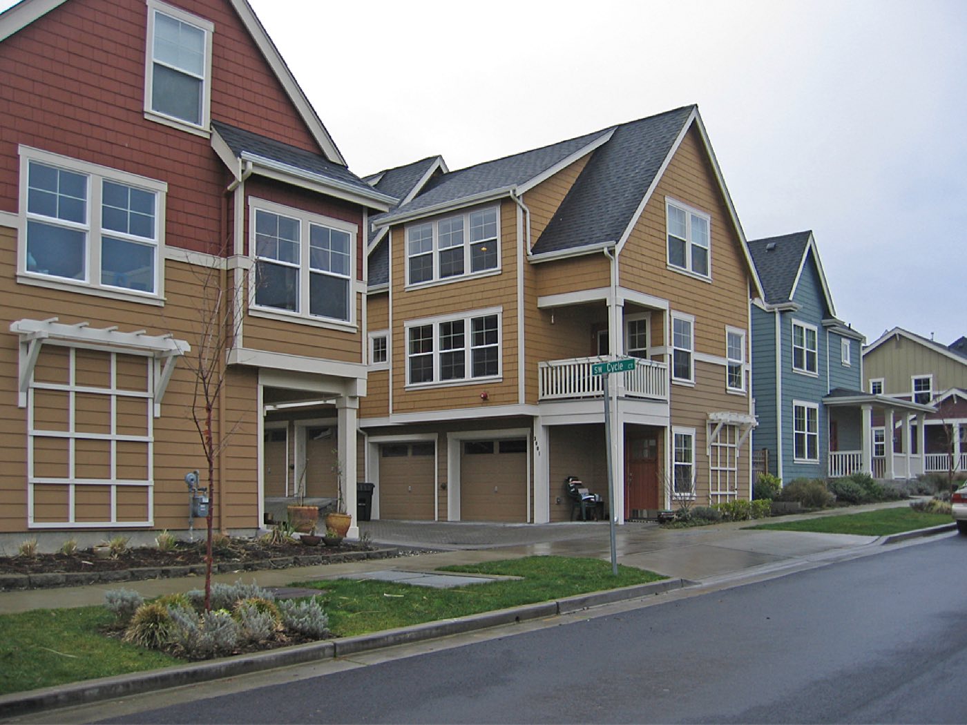 A row of garage doors opening onto a shared rear lane in Seattle's High Point neighborhood in West Seattle.